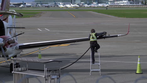 tripulación de tierra que alimenta el turbohélice haya 1900 en el aeropuerto, pan