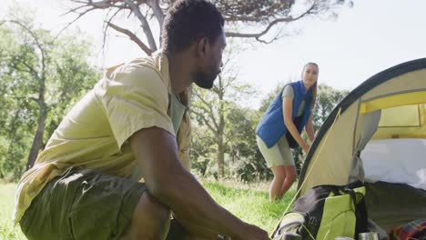 happy diverse couple camping with tent in park, slow motion