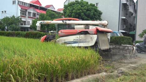 Tractor-Cosechador-De-Arroz-De-Máquina-Multifuncional-Que-Conduce-A-Través-De-Campos-De-Arroz-Cultivados,-Cosechando-Cosechas,-Trillando-Y-Aventando-En-La-Ciudad-De-Douliu,-Condado-De-Yunlin,-Taiwán