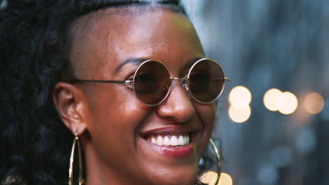 Fashionable-young-black-woman-in-sunglasses-enjoying-the-view,-head-shot,-bokeh-lights-in-background