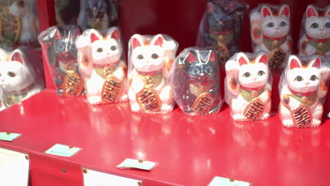 maneki cat, lucky cat, lined up outside of a market in kyoto, japan soft lighting