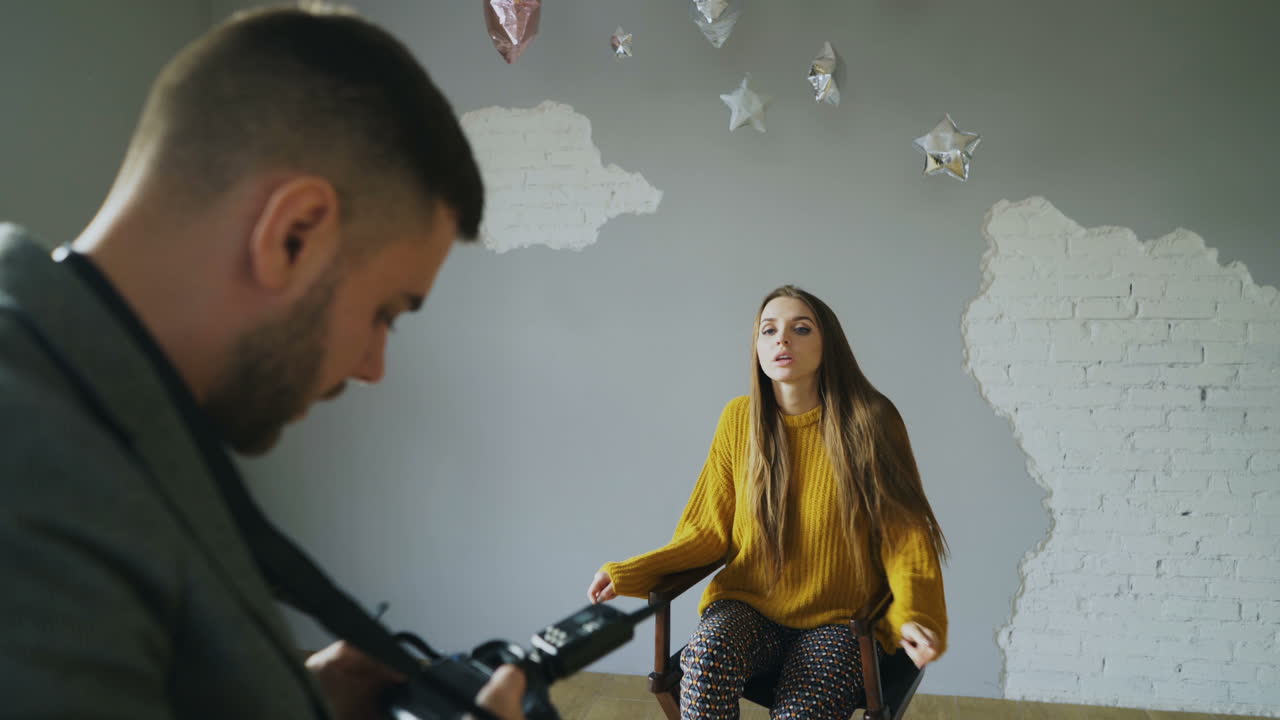 Photographer taking a portrait photo of a woman in a studio
