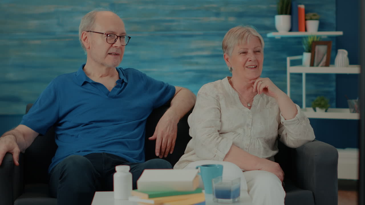 집에서 tv를 보는 고령 부부