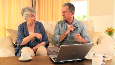 mature couple using a credit card