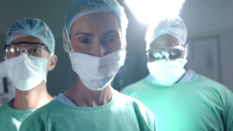 retrato de varios cirujanos serios con máscaras faciales en la sala de operaciones en cámara lenta