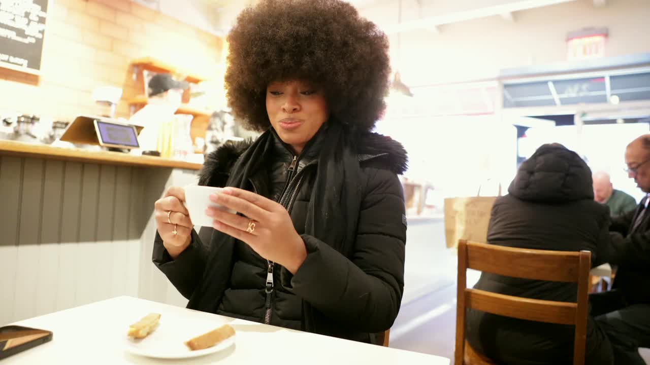 Woman with Afro Drinking Coffee in Cafe