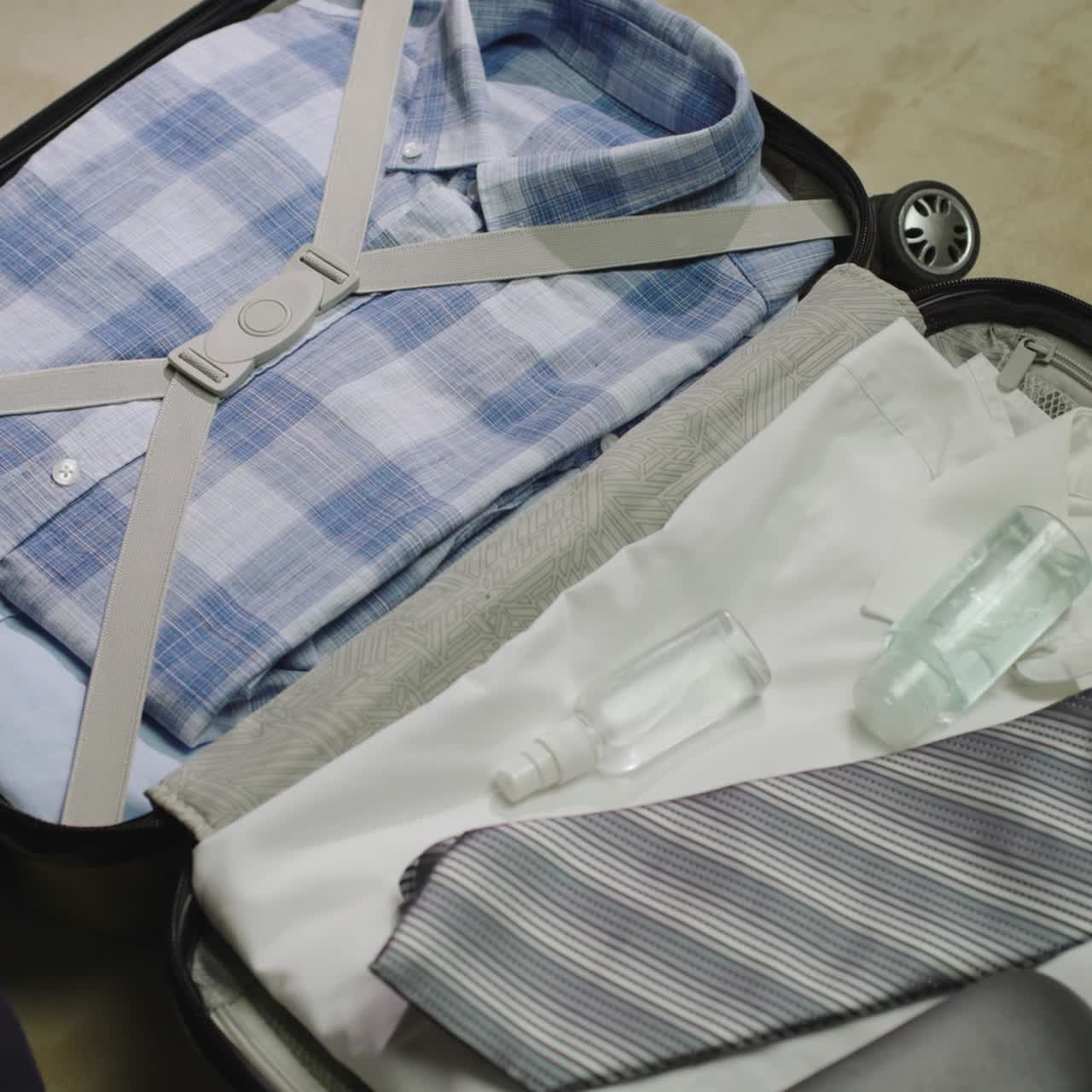 A woman packs clothes and face mask for a business trip
