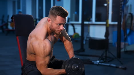 handsome power athletic man bodybuilder doing exercises with dumbbell. fitness muscular male on gym background. fitness concept. slow motion.