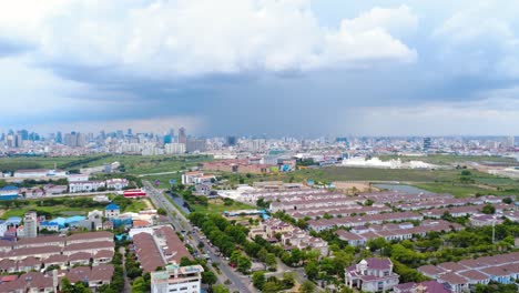 aerial footage of phnom penh's sprawling cityscape under dramatic cloud cover. captivating bird's eye view, vibrant greens and urban layout under moody skies.
