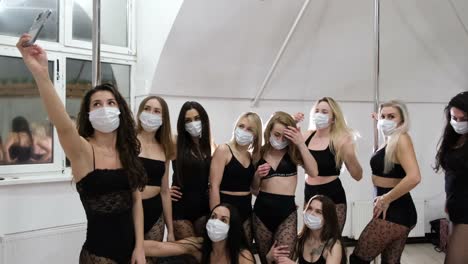 a group of sexy girls in protective masks take pictures of themselves on a smartphone a group of sexy girls in protective masks take pictures of themselves on a smartphone dance group in sexy clothes beautiful girls