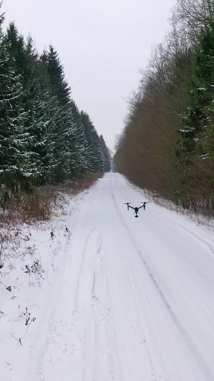 Drone flying over forest. Flying drone on the background of snow covered forest
