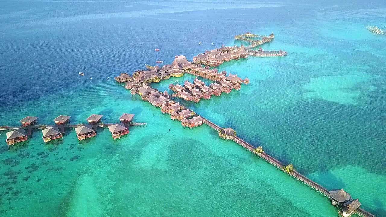 vuelo aéreo sobre aguas cristalinas y resort en malasia, toma constante de larga distancia en cámara lenta