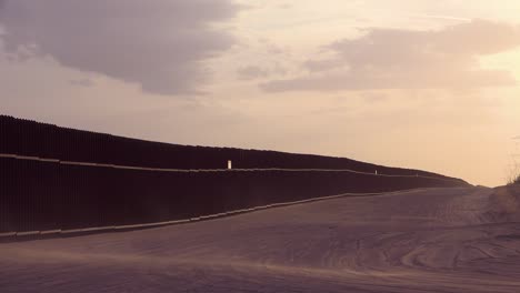 el polvo sopla al atardecer en el muro fronterizo en la frontera entre méxico y estados unidos cerca de las dunas de arena imperiales de california 1