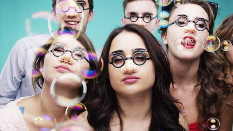 friends having fun with bubbles and funny glasses