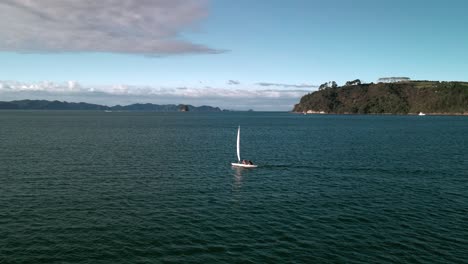 sailing yacht into the sunset of mercury bay in coromandel, new zealand