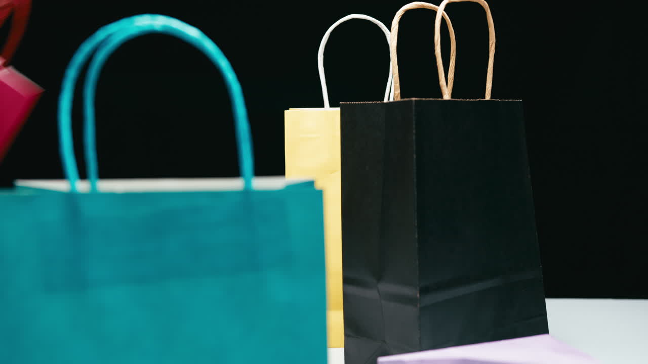 Gift bags being exchanged frantically on a black background at a shop counter
