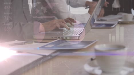 animation of lights and graphs over hands of diverse businesspeople working on laptops