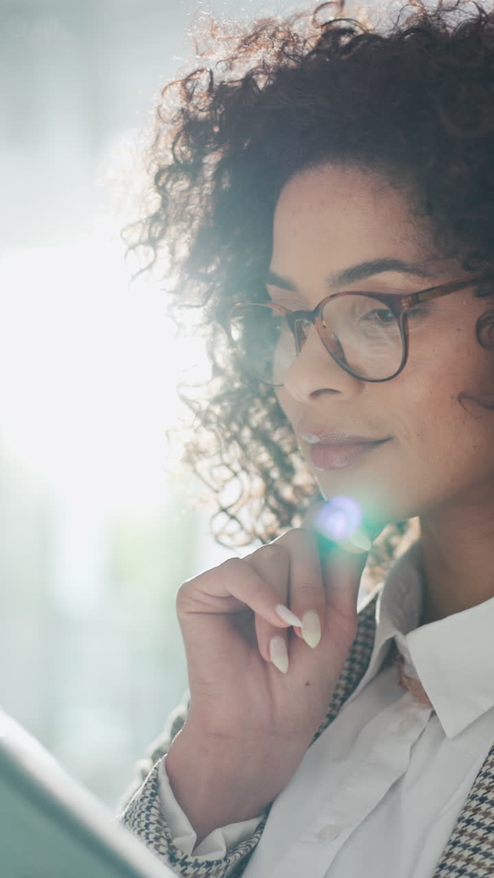 Close-up of a Thoughtful Businesswoman with Curly Hair and Glasses