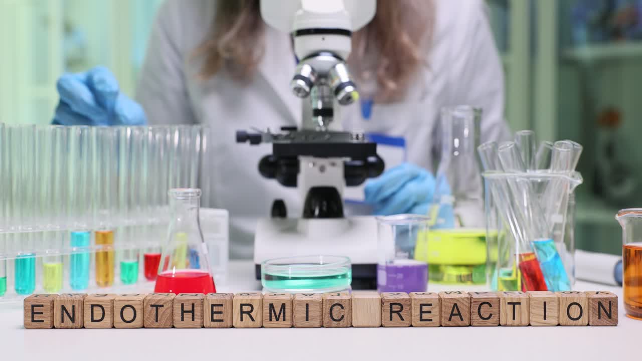 Laboratory worker observes chemical reaction through microscope
