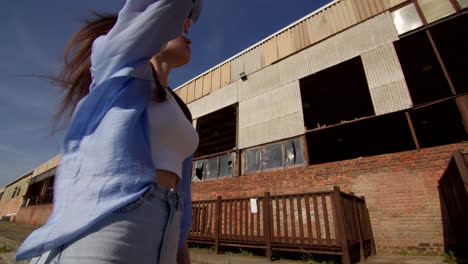 woman in front of an abandoned factory