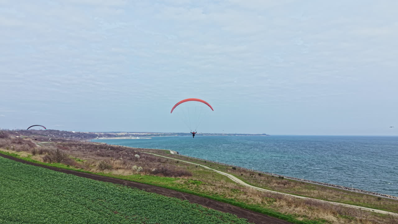 Emocionante aventura de parapente sobre el océano cerca de una costa abierta en un día despejado