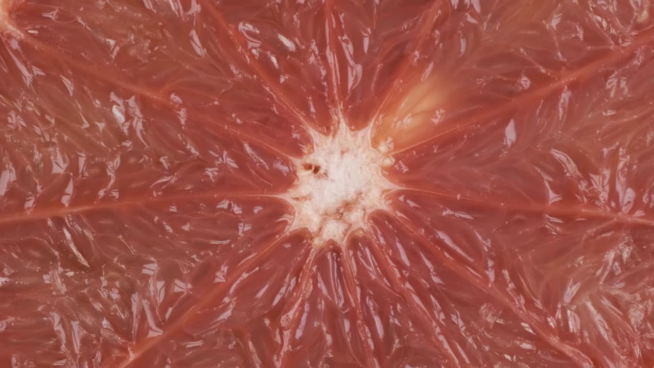 Rotation, closeup of fresh, juicy pulp of an grapefruit. Background and texture of grapefruit. Top view.