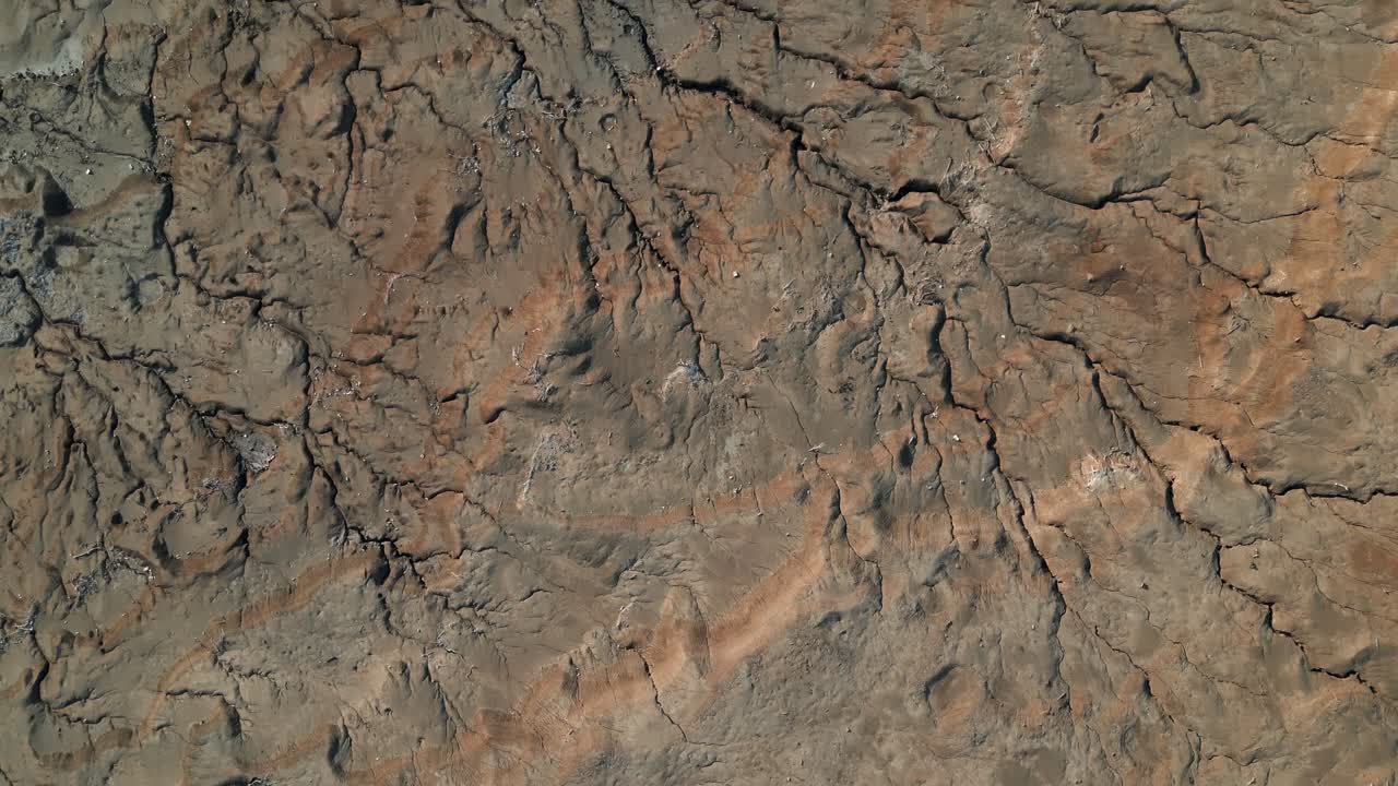 사막의 풍경 위에서 공중에서 찍은 사진. 땅의 질감과 균열을 보여줍니다.