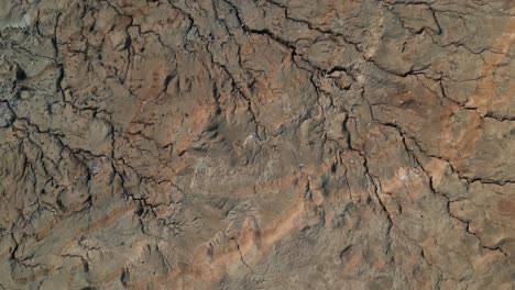 aerial top-down shot over desert landscape showing texture and cracks in the earth