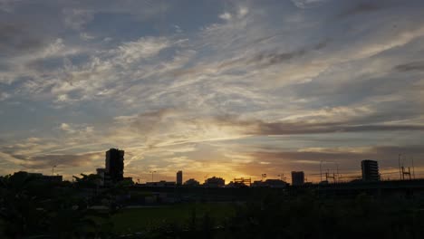 a serene sunset scene over the tokyo skyline, with buildings silhouetted against a colorful, cloudy sky