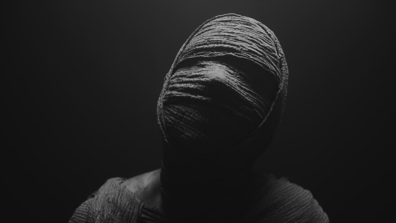 A mummy of a woman on a dark backdrop turns her head