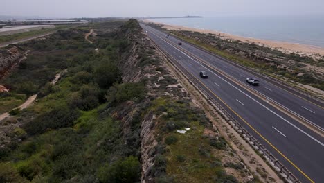 Cars-Moving-Along-the-Coastal-Highway-in-Megadim-Moshav,-Israel---Drone-Flying-Forward