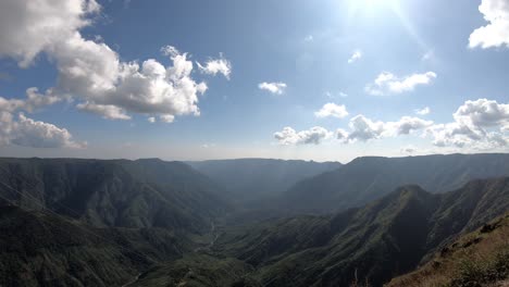 Schlucht,-Hügel-Und-Landschaft-Mit-Sich-Bewegenden-Weißen-Wolken-Auf-Blauem-Himmel-Und-Grüner-Landschaft