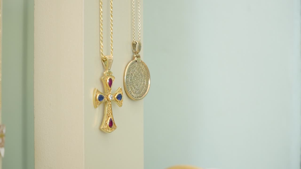 A stunning display showcases exquisite gold jewelry featuring intricate designs and colorful gemstones. The setting highlights the elegance and craftsmanship of each piece