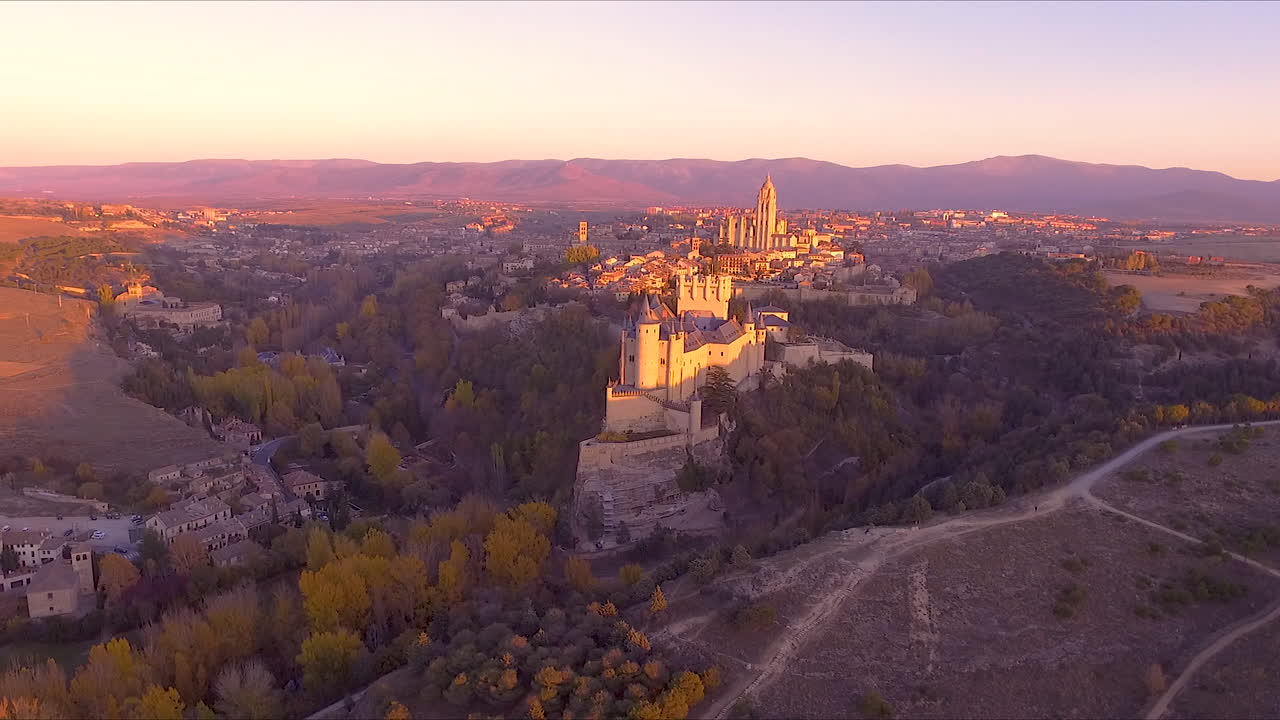 vista aérea del alcázar de segovia y la ciudad durante el otoño con hermosos colores de árboles y puesta de sol