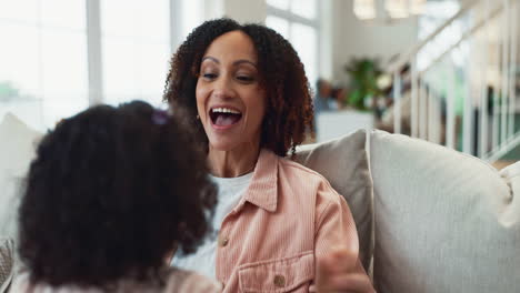mother and daughter laughing and playing together at home