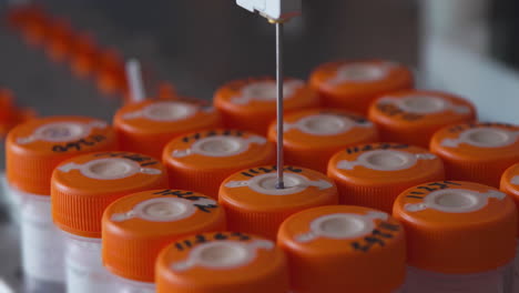 close-up in the medical laboratory, the robot pierces a jar of liquid with a needle and pours it into a tube for further analysis by the doctor