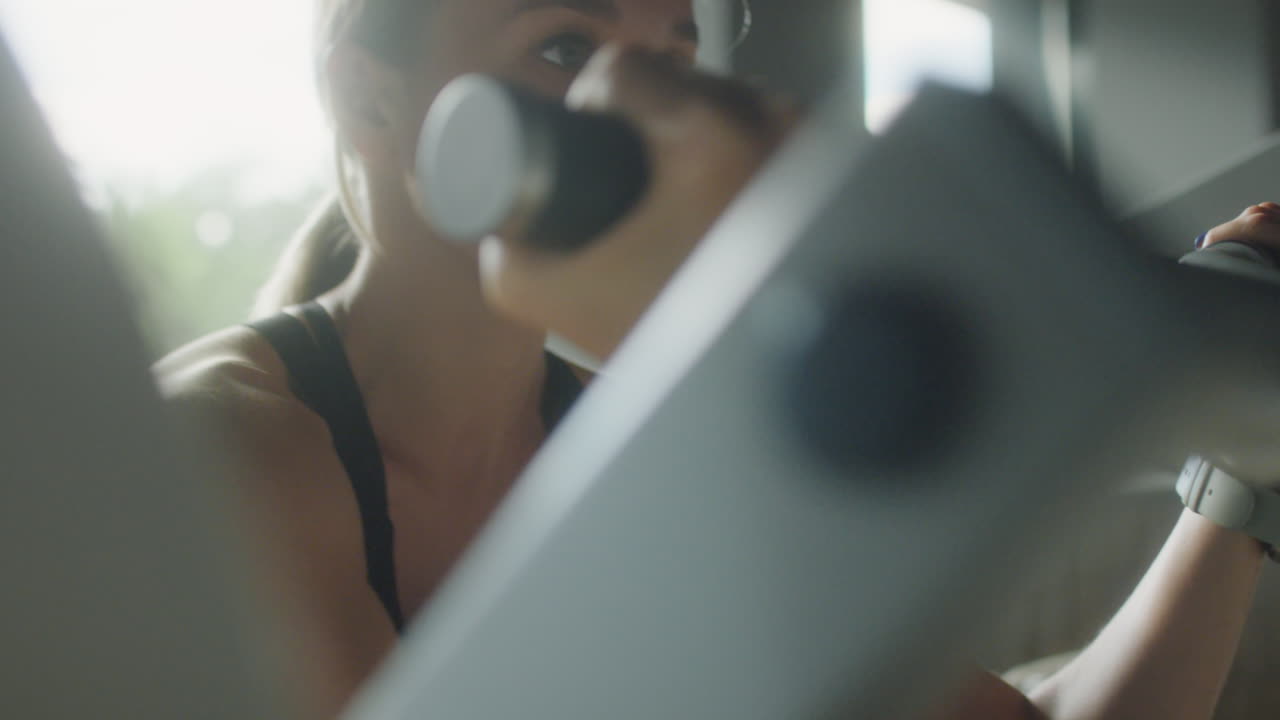 Woman Training with Preacher Curl Machine in Gym