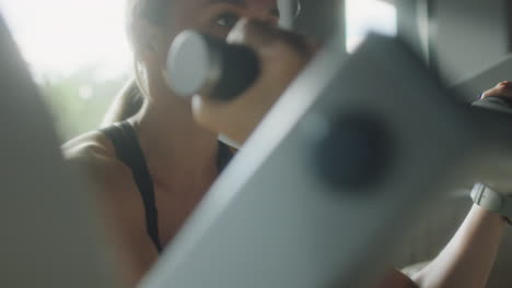 woman training with preacher curl machine in gym