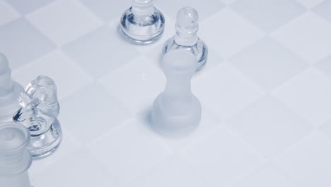 A-chess-match:-a-rook-eating-a-king-on-a-chessboard-made-of-glass-material