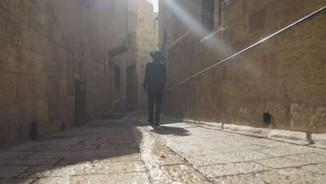 man walking through the narrow streets of jerusalem's old city