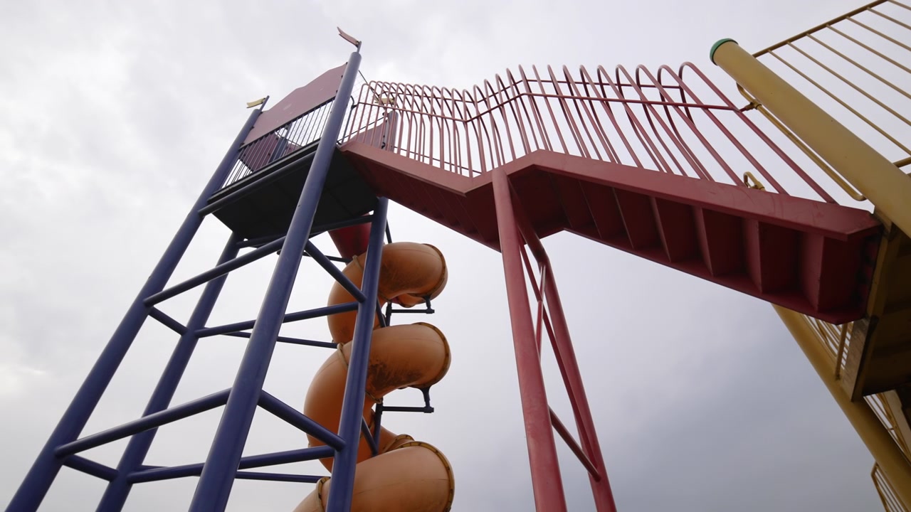 Colorful outdoor playground equipment with spiral slide and stairs.