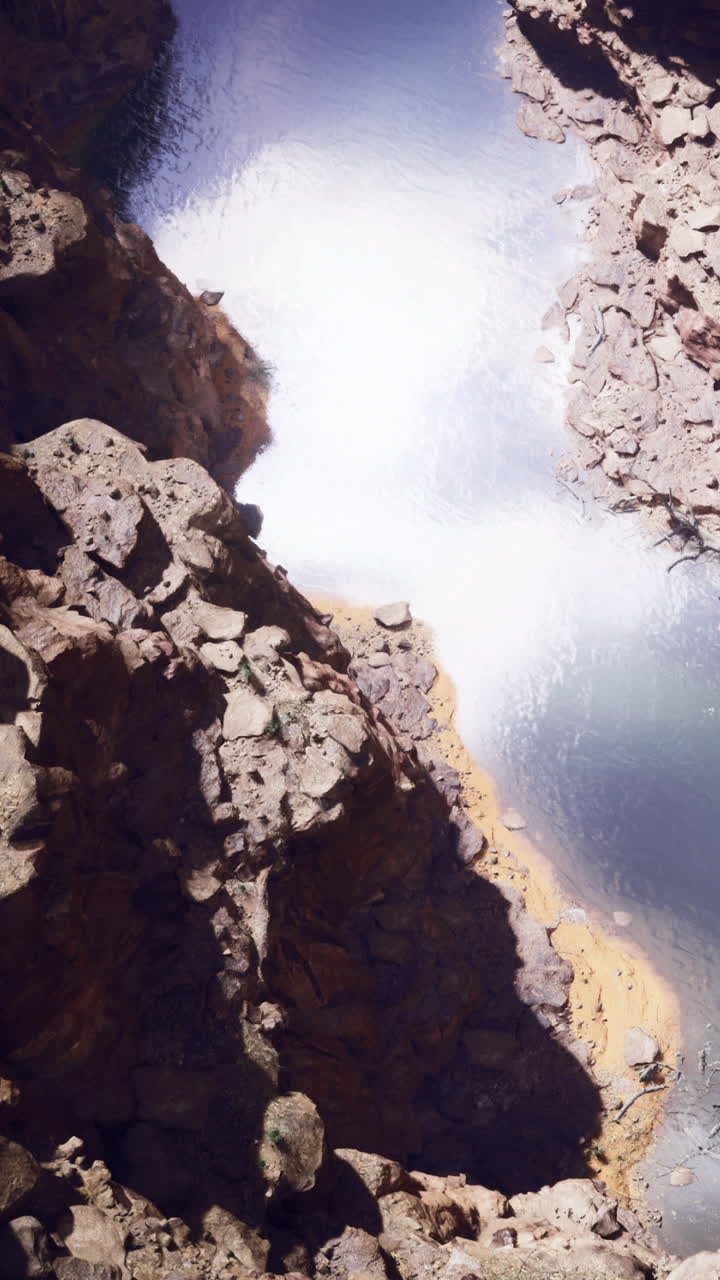 Fiume maestoso che scorre attraverso un canyon roccioso sotto il sole pomeridiano.
