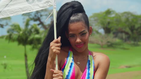 a young girl wearing a bikini and basking in an open field on trinidad, a tropical caribbean paradise close up