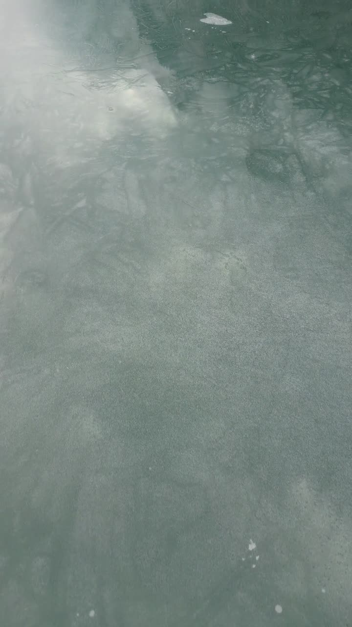 Thin layer of black ice surface of Klöntalersee Klöntal lake Switzerland vertical video reel nature