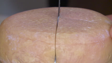 cutting a round cheese wheel