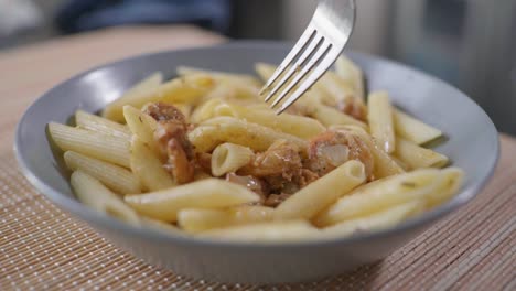 close-up of digging a fork into a delicious bowl of shrimp pasta