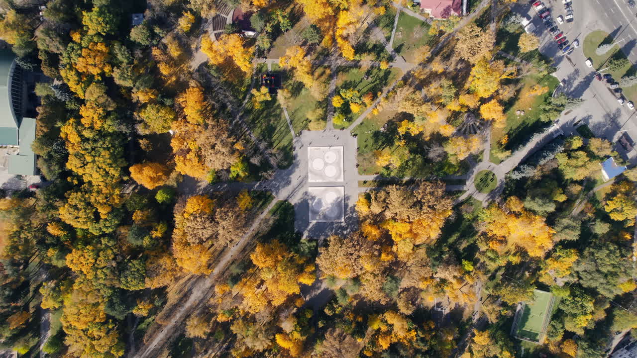 Aerial drone view of a square in Chisinau, Moldova. Park full of yellowed trees, vertical view
