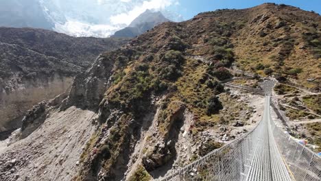 experimente la emoción de caminar a través de un puente colgante vertiginosamente alto y largo en los himalayas, con una perspectiva impresionante de las montañas y valles circundantes.