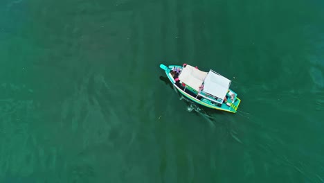 A-colorful-traditional-sailboat-sails-through-green-water-in-Paratay,-Brazil