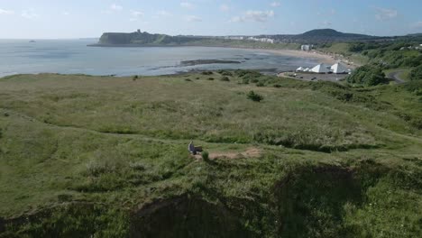 Aerial-view-of-North-bay,-Scarborough,-North-Yorkshire-with-cliffs,-coastline,-ocean,-and-castle